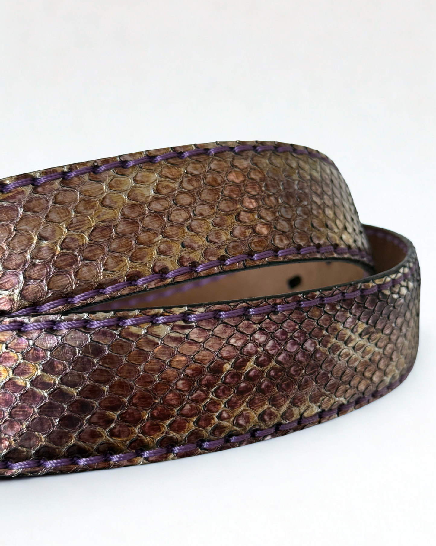 Close up of python leather texture on vintage JMADE belt in purple and gold