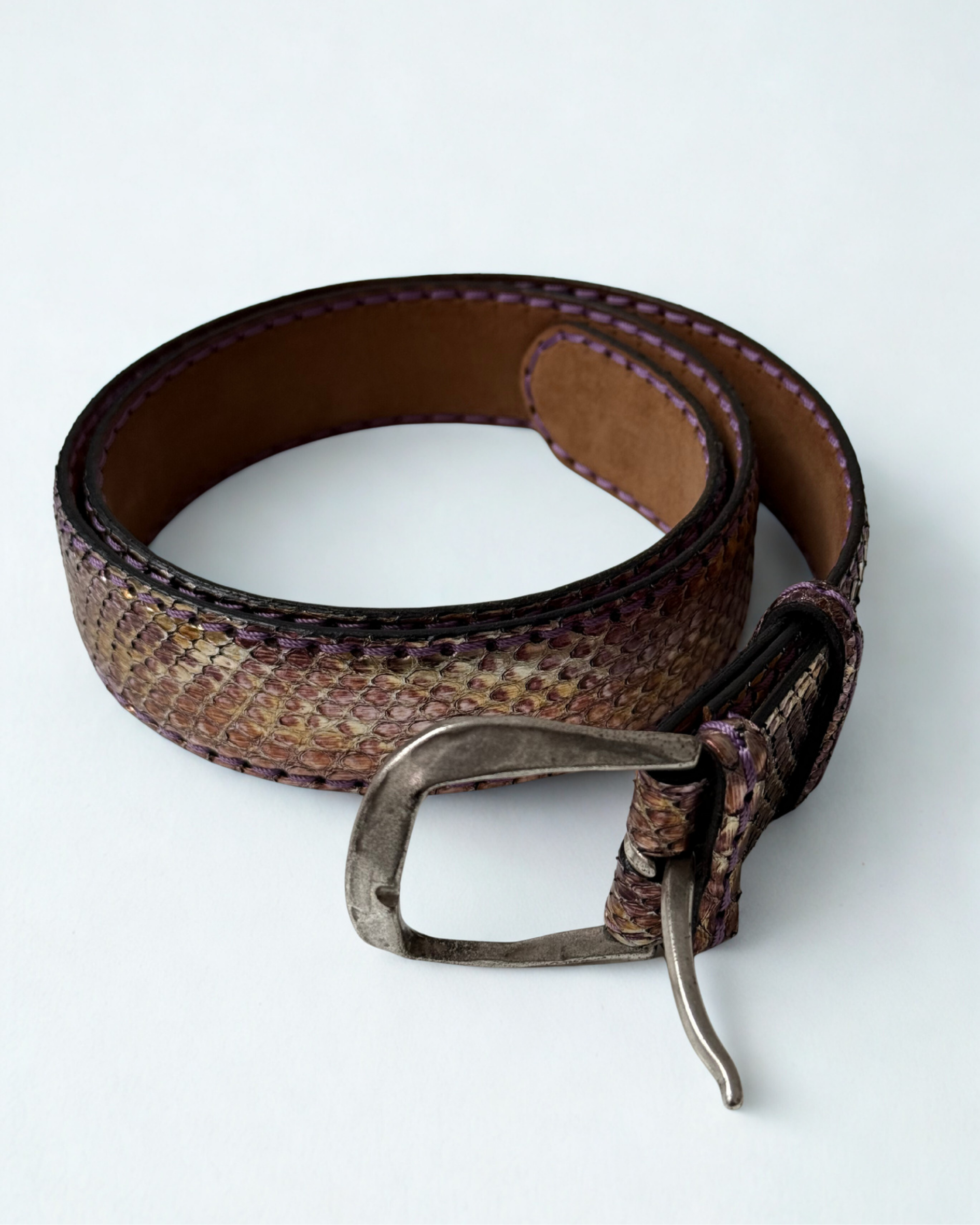 Close up of buckle on vintage JMADE belt in purple and gold