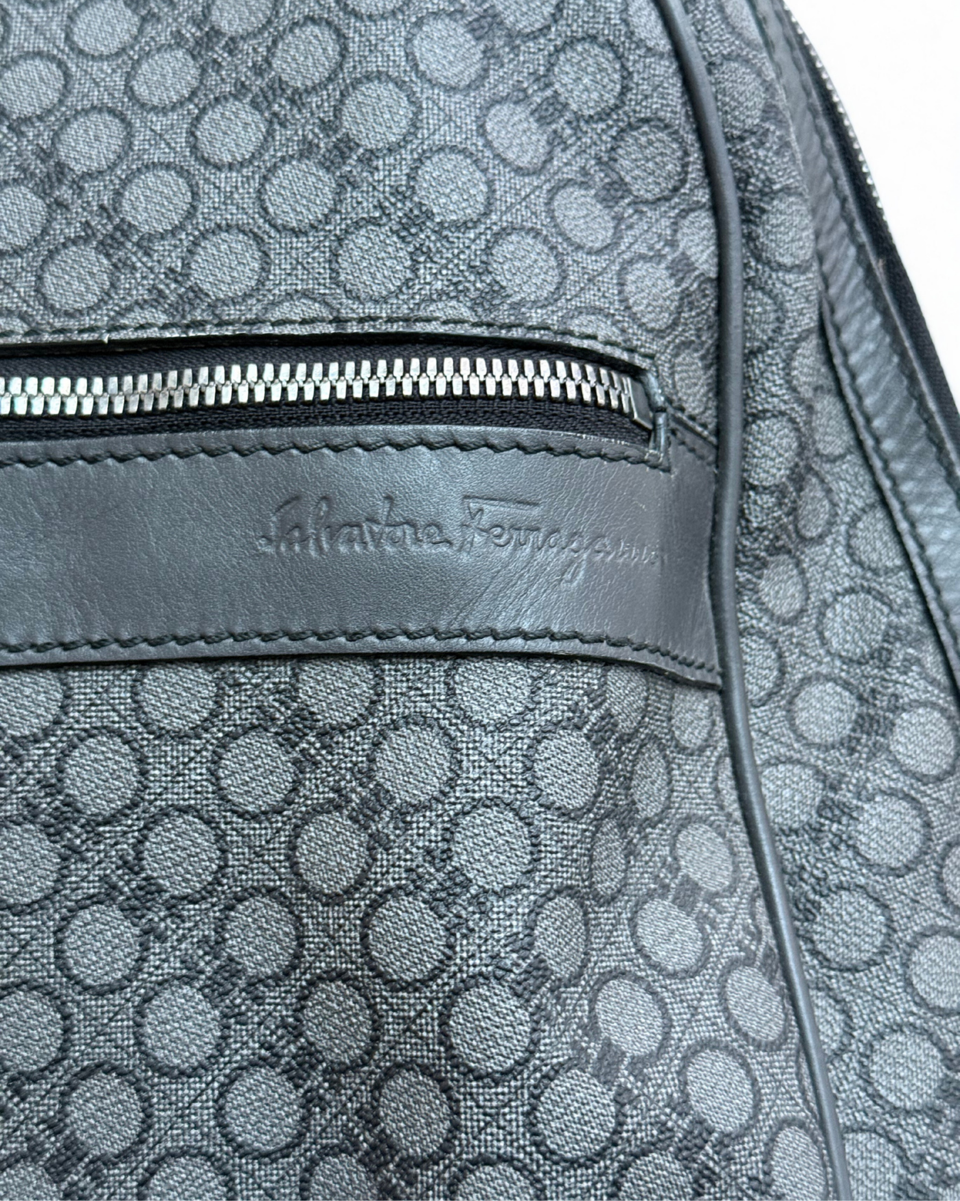 Close-up of a patterned backpack with Salvatore Ferragamo logo.