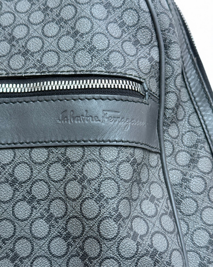 Close-up of a patterned backpack with Salvatore Ferragamo logo.