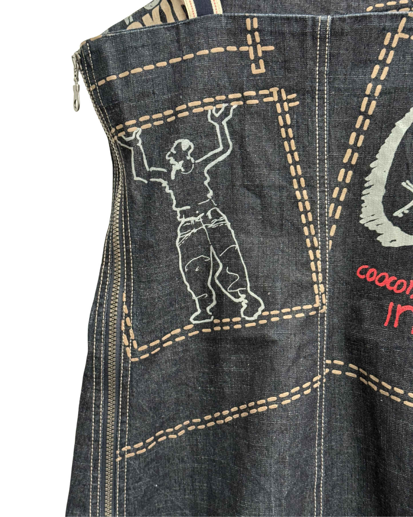 Denim dress with embroidered design of a person on a tightrope and text.