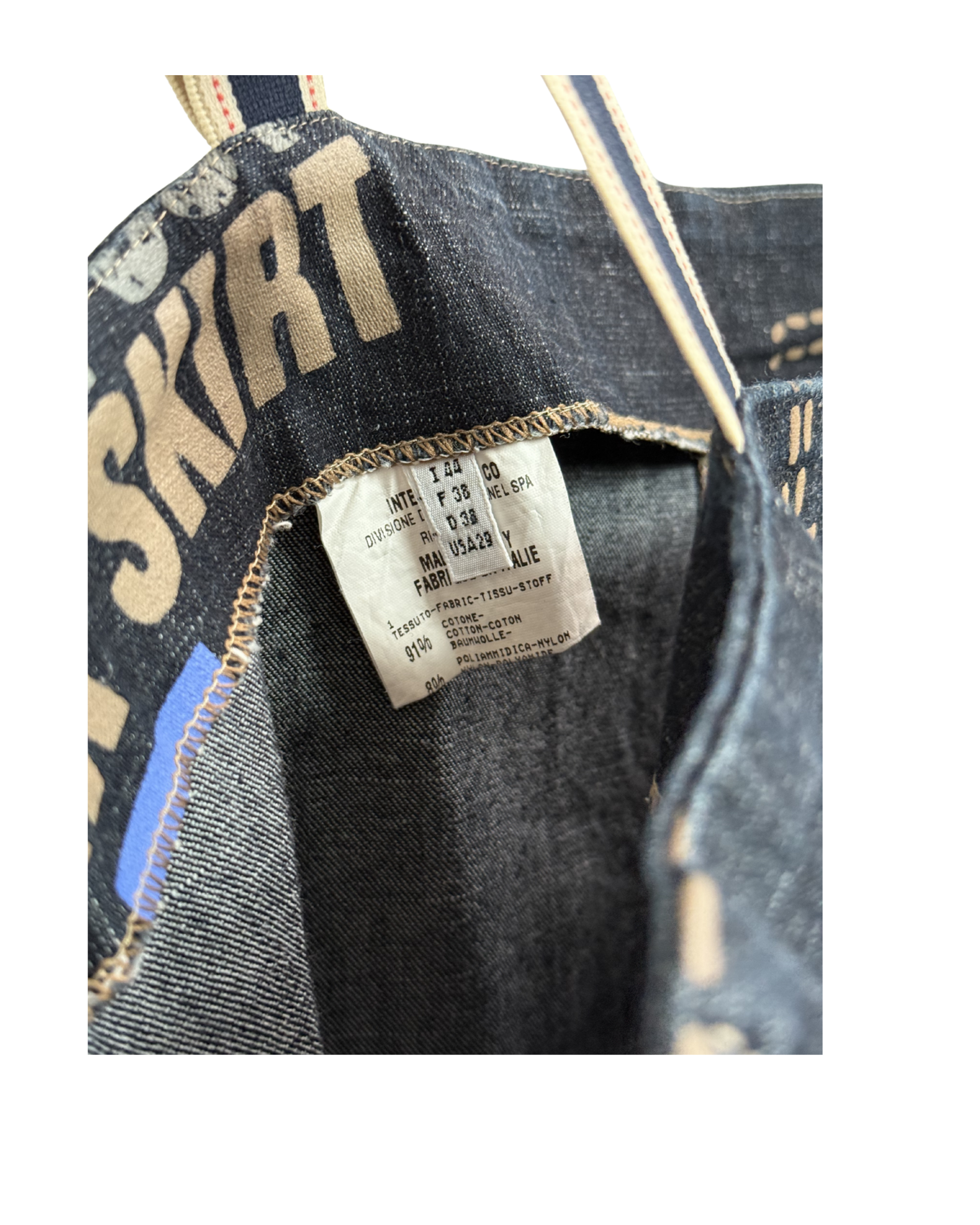 Close-up of a denim dress with a size label on a white background