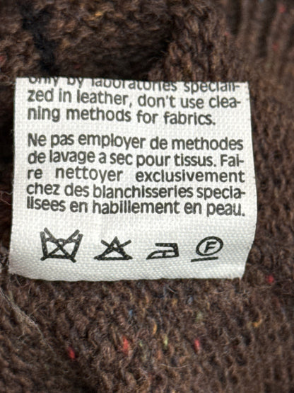 Clothing label on a textured fabric background with care instructions.