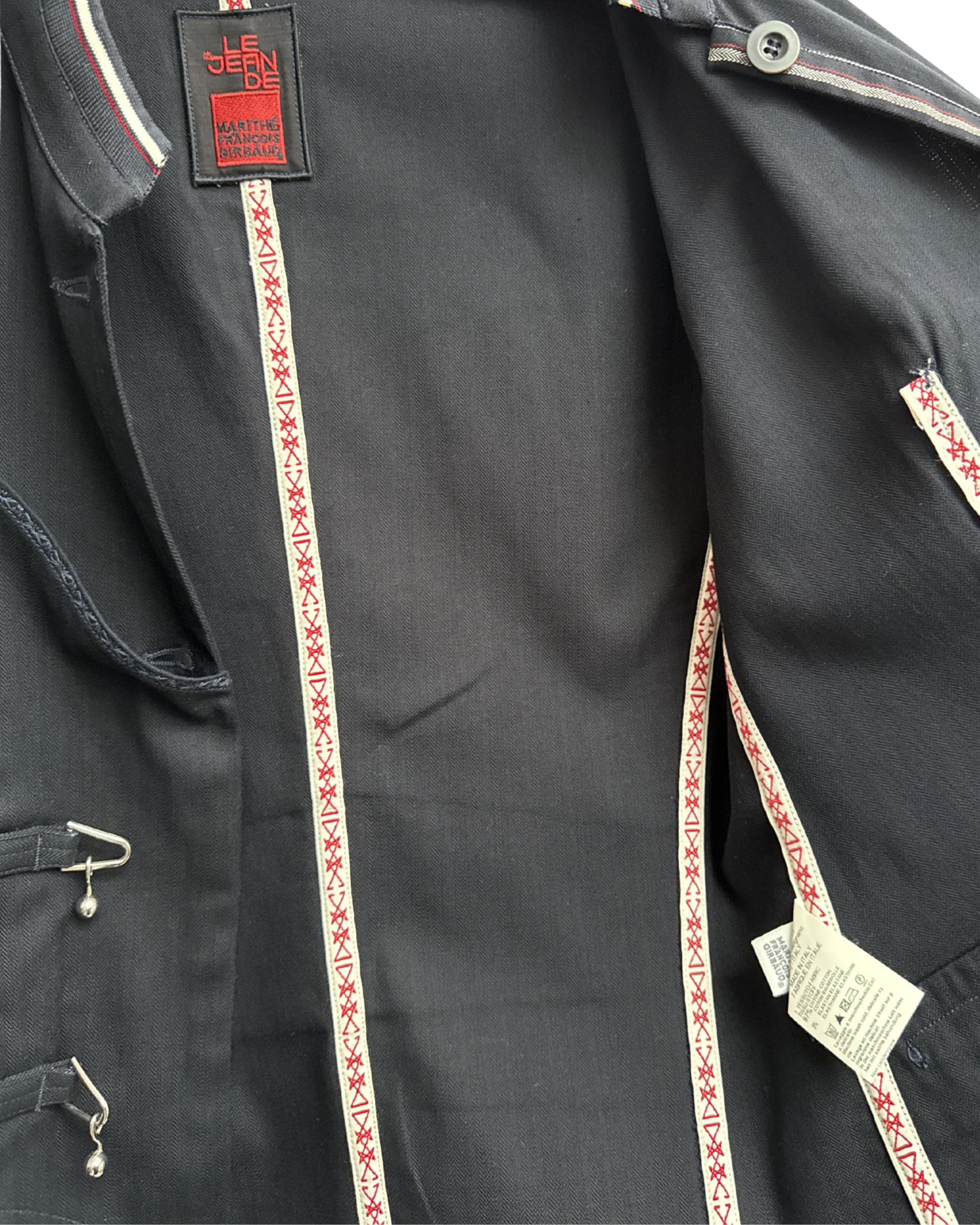 Navy jacket inside with decorative red and white trim on a white background