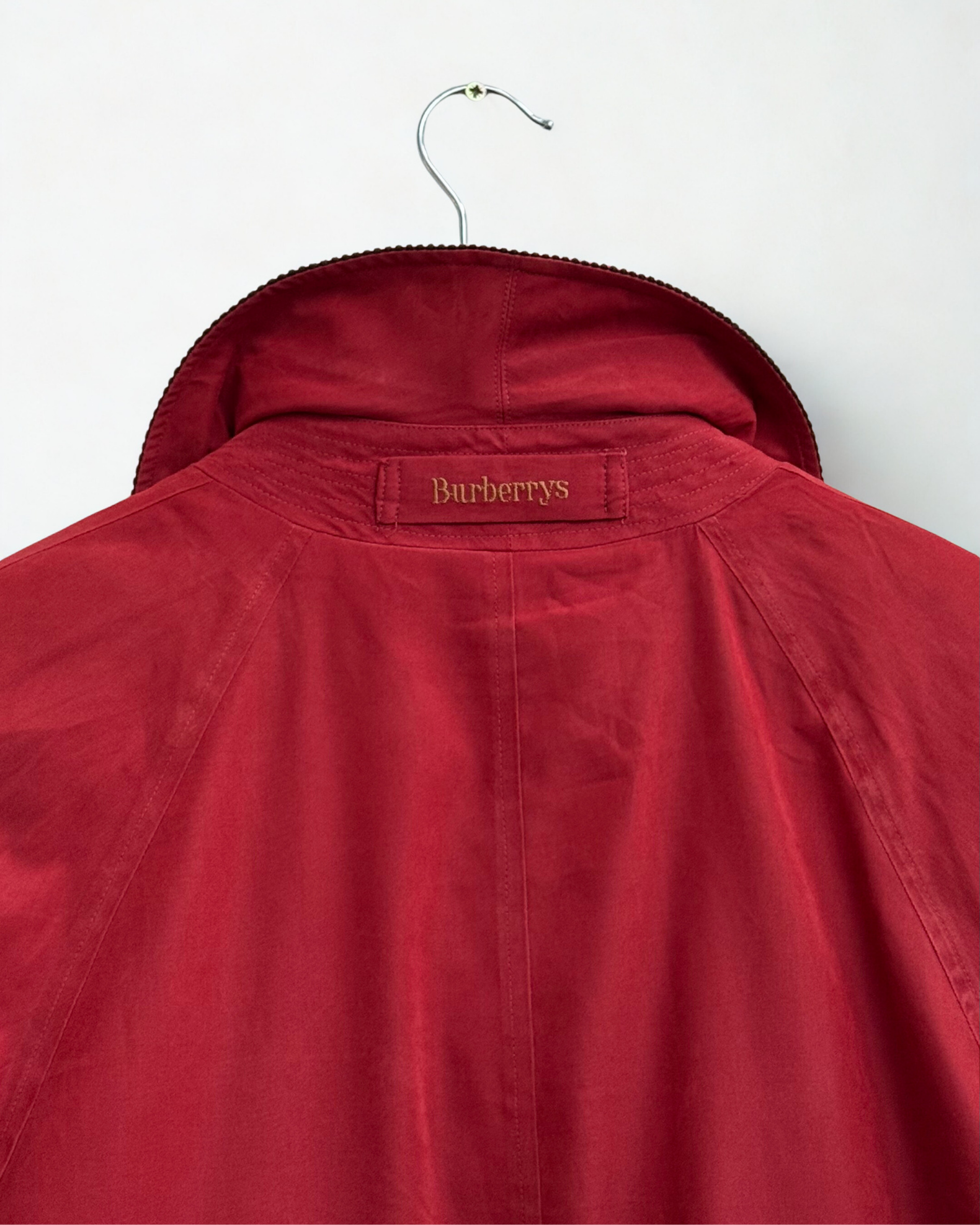 Red jacket with Burberrys label on the collar on a white background