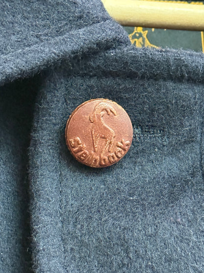 Leather embossed logo button detail on Steinbock loden jacket