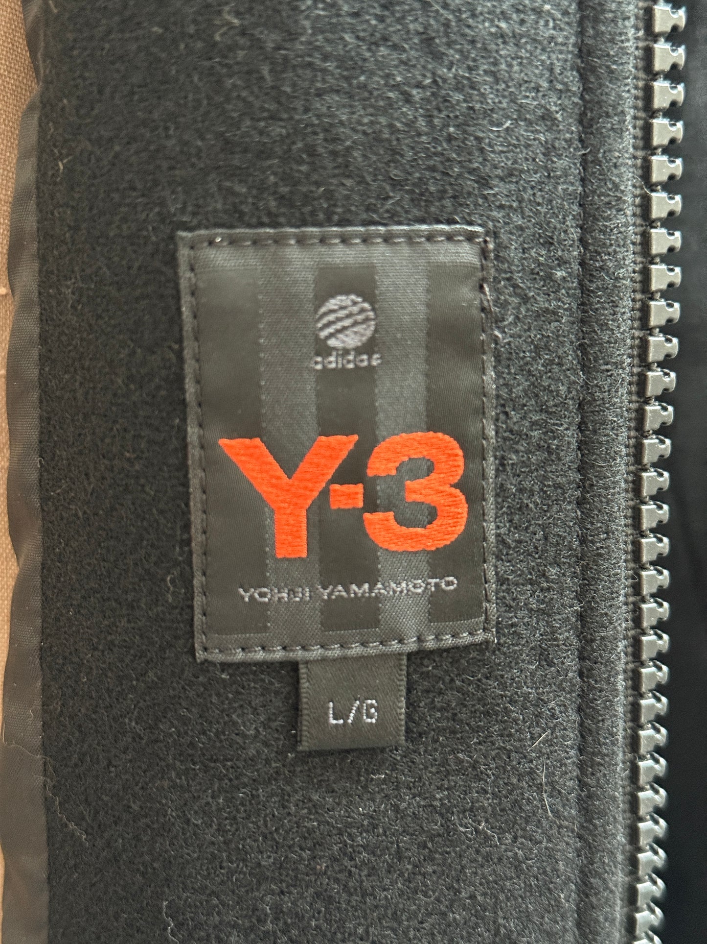 Close-up of a Y-3 label on a black fabric surface