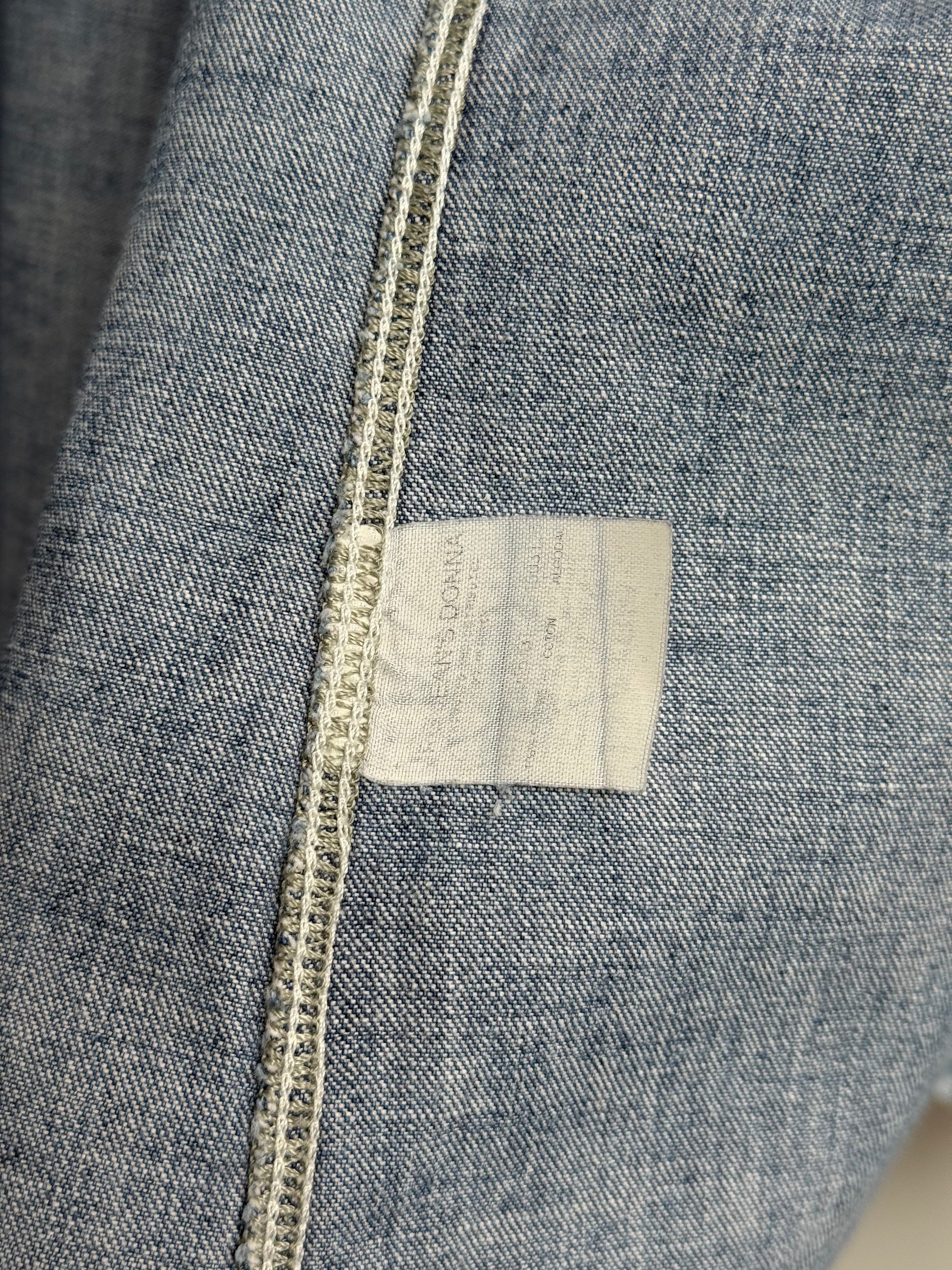 Close-up of a denim fabric with a label and stitching details.