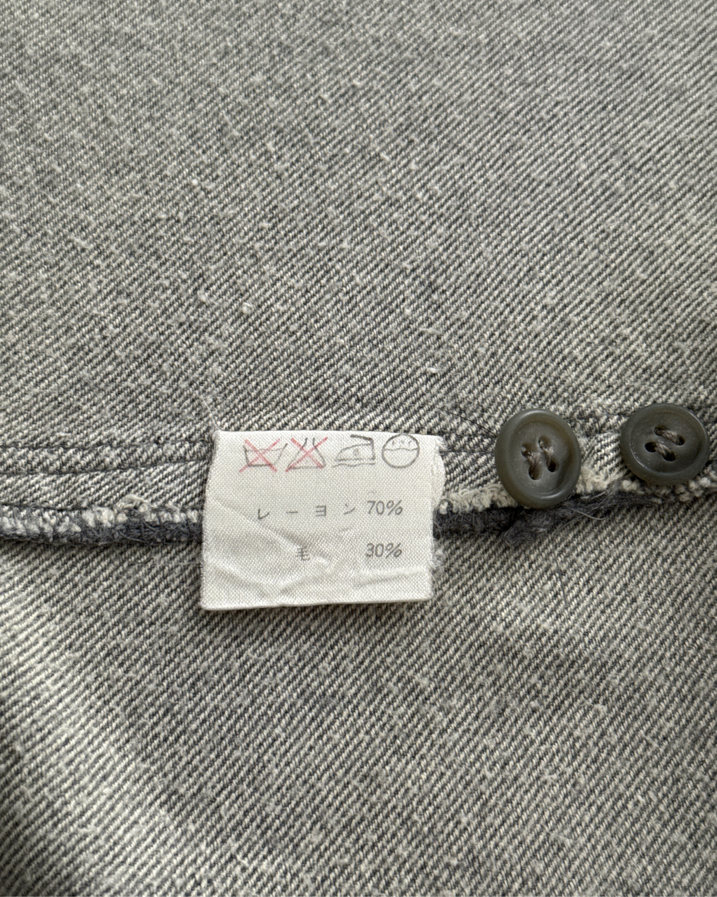 Fabric with a label showing material composition on a gray textured background