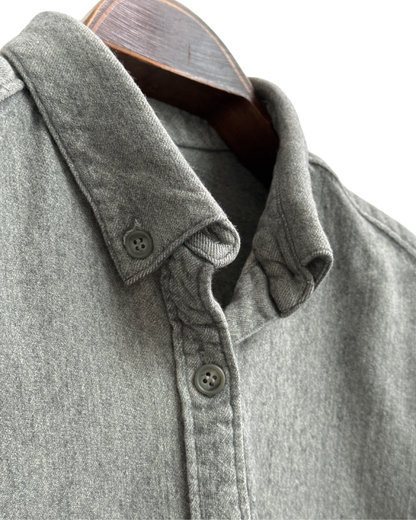 Close-up of a gray shirt with collar and buttons on a white background