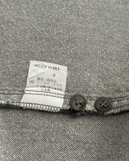 Close-up of a grey fabric with a label and buttons.