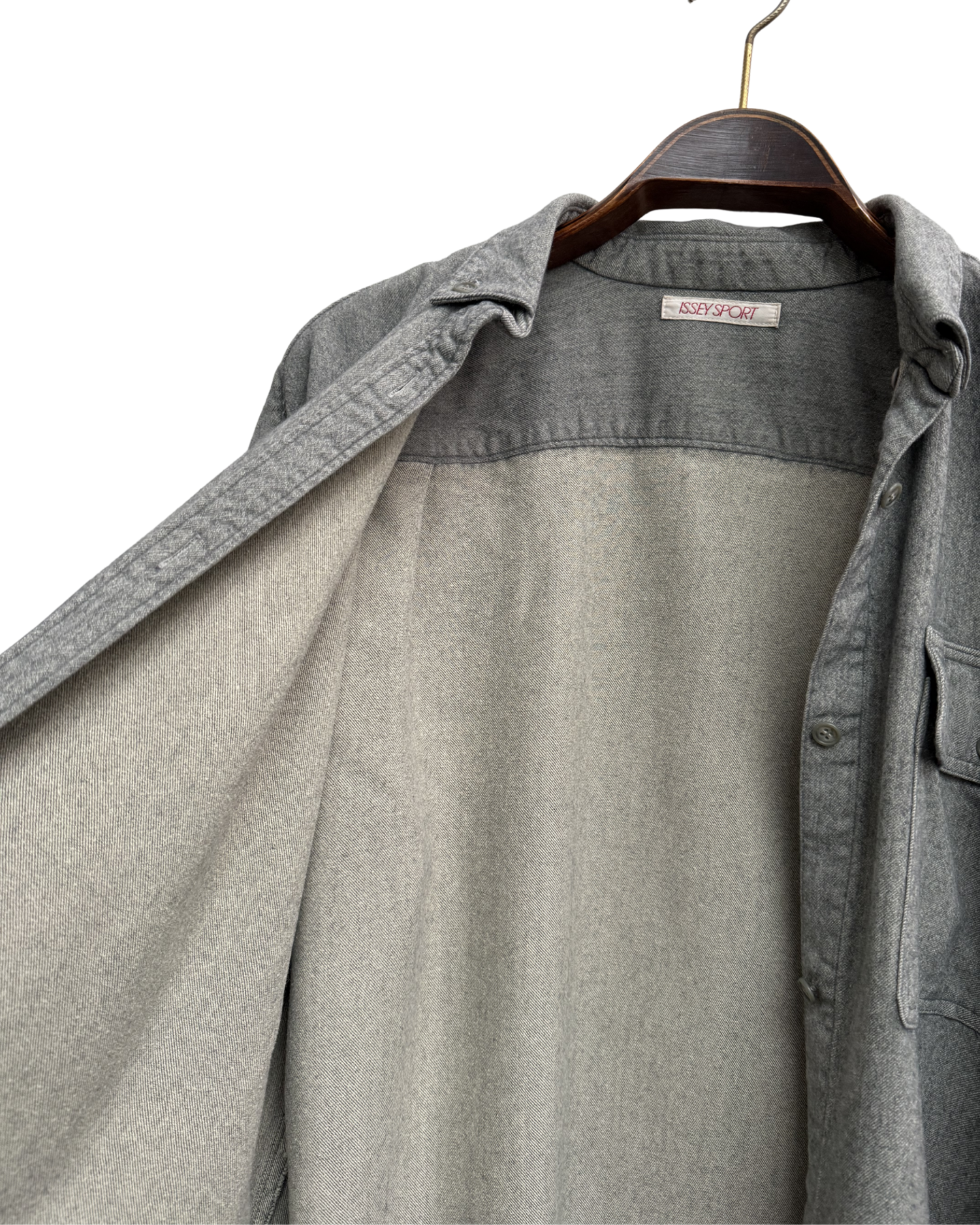 Inside of grey shirt on a hanger with a visible brand label.