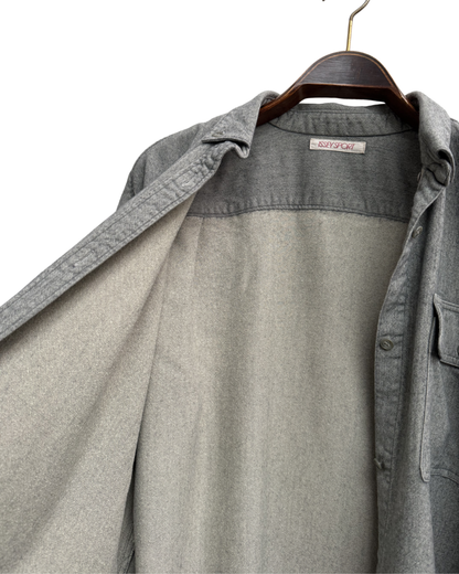 Inside of grey shirt on a hanger with a visible brand label.