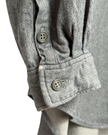 Close-up of a gray textured shirt with sleeves and buttons on a white background
