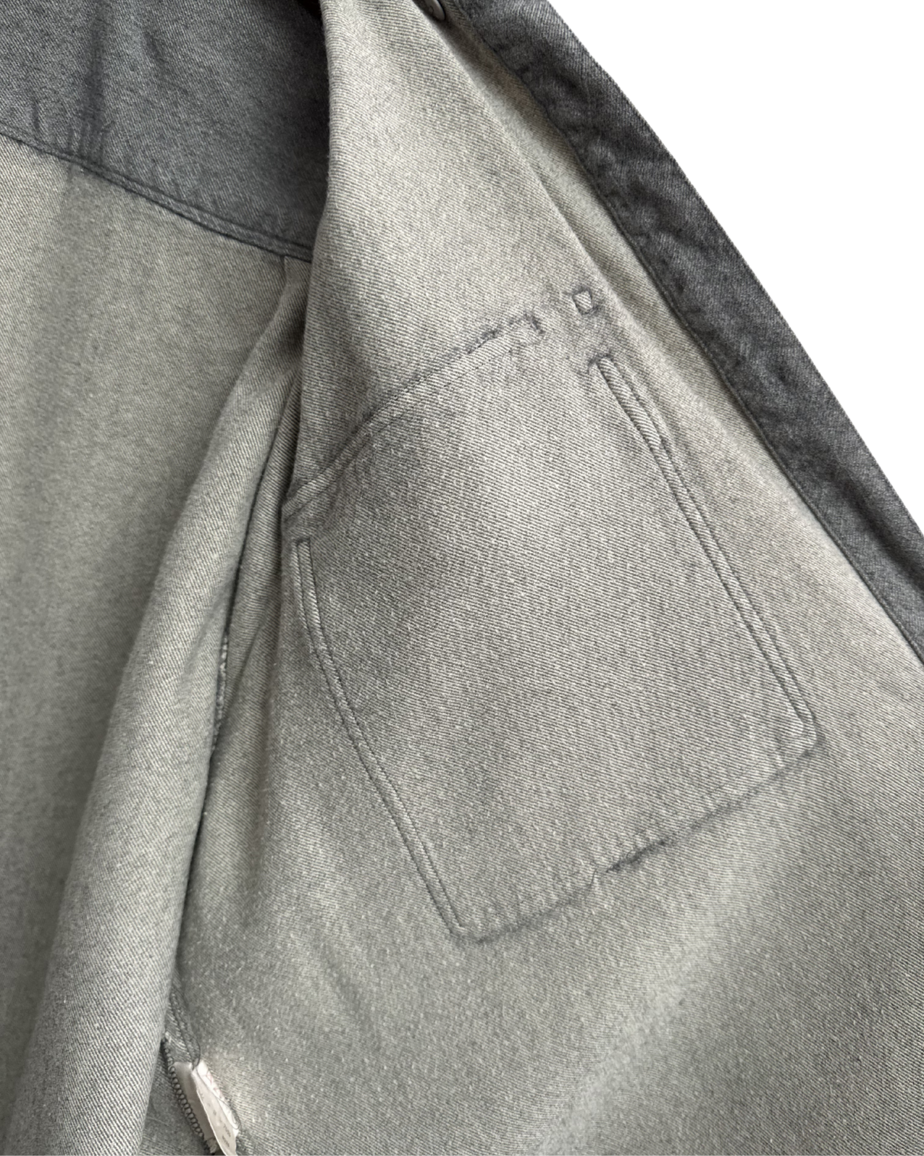 Close-up of a grey shirt with a inside pocket detail on a white background