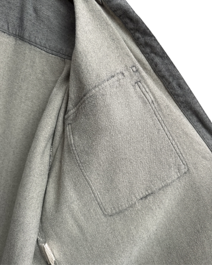 Close-up of a grey shirt with a inside pocket detail on a white background